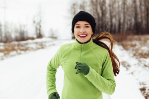 Happy young woman running in winter